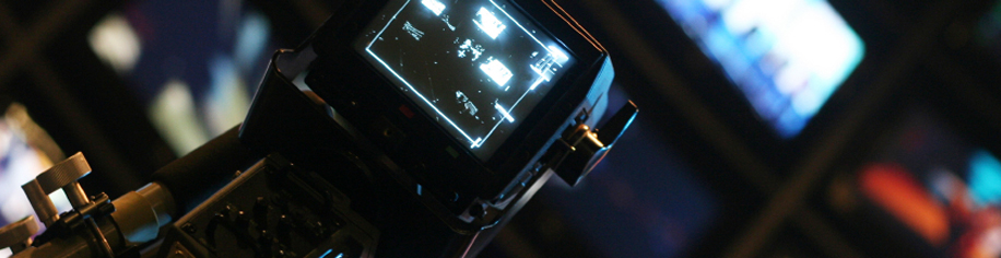 Camera in front of TV monitors in a broadcasting room